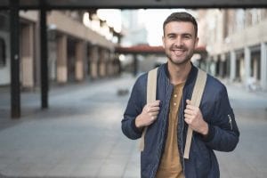 man with backpack smiling student